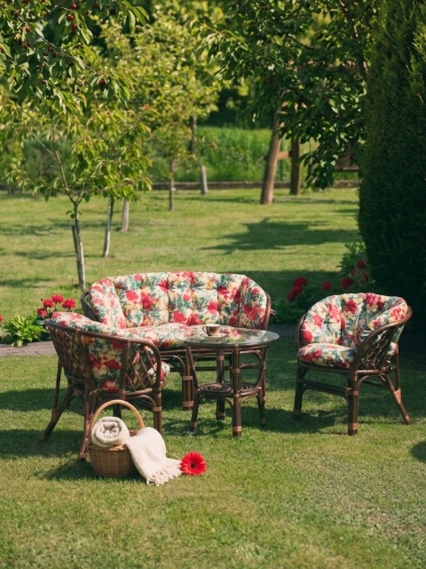 Rattan-Gartenmöbel mit floralen Kissen