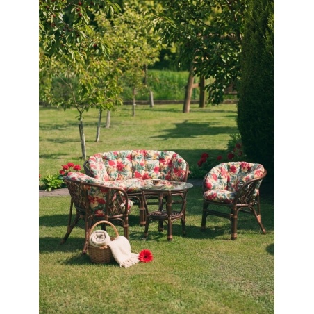 Rattan-Gartenmöbel mit floralen Kissen