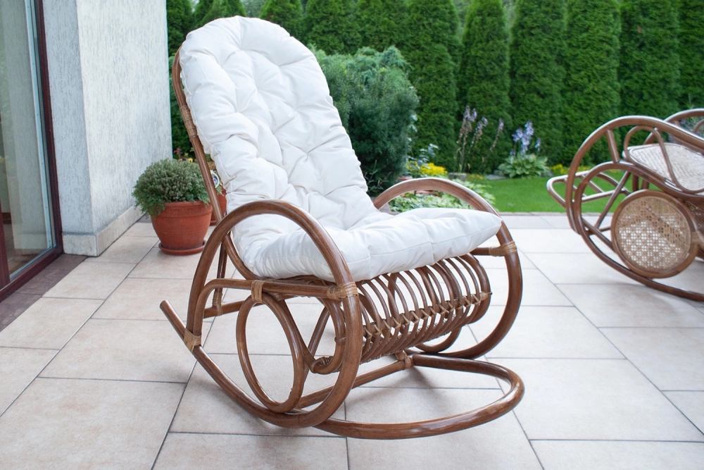 Rattanowy fotel bujany z białą poduszką