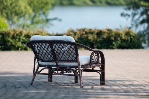 Rattansbank im kolonialen Stil mit Kissen